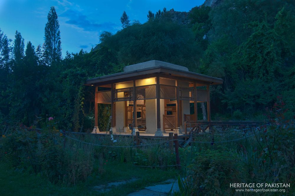 Garden pavilion glows warmly as twilight deepens over Shigar Fort.
